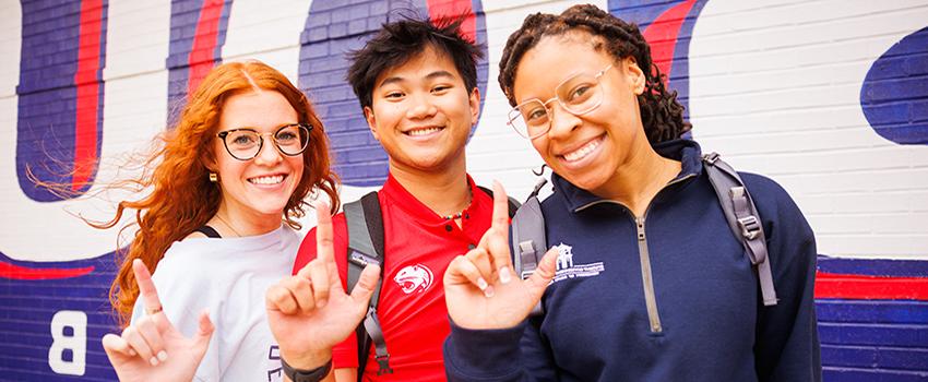 Three South Alabama students holding up the J sign for Jaguars.